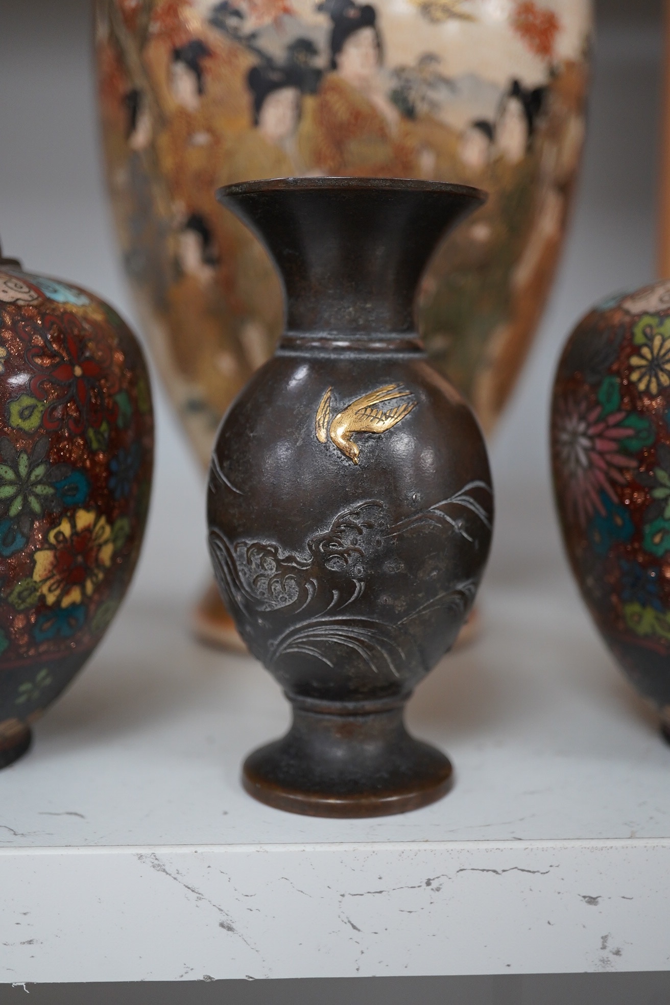 A pair of Japanese cloisonné enamel jars and covers, a Japanese bronze and gold overlaid small vase and a Satsuma pottery vase, tallest 22cm high (4). Condition - finial loose and one missing on cloisonné jars and covers